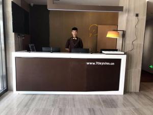 a man standing behind a counter in an office at IU Hotel Kunming Jinma Bijifang Joy City in Kunming