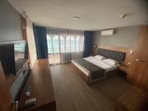 Habitación de hotel con cama y TV en Divine Beach Resort Kumburgaz, en Büyükçekmece