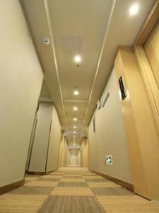 un pasillo en un edificio de oficinas con un pasillo largo en Chonpines Hotels·Guangzhou Baiyun Yongtai Metro Station, en Guangzhou