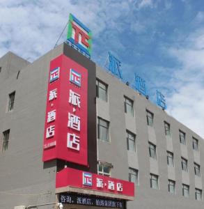 a building with a red sign on the side of it at PAI Hotels·Yinchuan International Trade City in Yinchuan