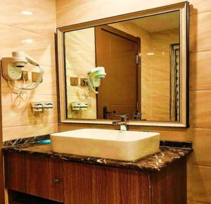 PAI Hotels·Yinchuan International Trade City في ينشوان: حمام مع حوض ومرآة كبيرة