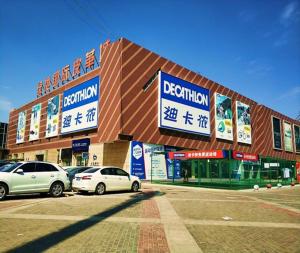 PAI Hotels·Yinchuan International Trade City في ينشوان: مبنى فيه سيارات تقف امامه