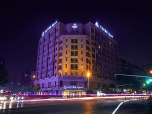 a building with lights on top of it at night at Magnotel Hotel Wuhan Meiyuan Xiaoqu Metro Station Dream Times in Wuhan +12 photos