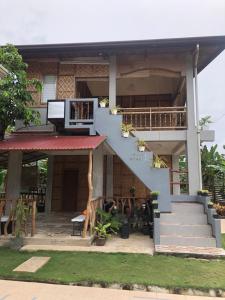 ein Haus mit einer blauen Treppe und einem Balkon in der Unterkunft MIOKI HOMETEL in Batuan