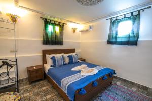 a bedroom with a bed with blue sheets and pillows at Riad Fes Lile in Fès