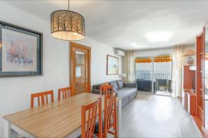 - une salle à manger et un salon avec une table et des chaises dans l'établissement Apartment Arena - Lloret de Mar, à Lloret de Mar