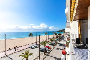 - une vue sur la plage depuis le balcon d'un bâtiment dans l'établissement Apartment Arena - Lloret de Mar, à Lloret de Mar