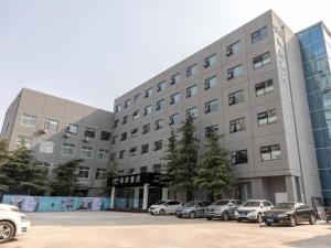 duży budynek z samochodami zaparkowanymi na parkingu w obiekcie Xana Hotelle·JiNan Daminghu East Gate Shandong University w mieście Hongjialou