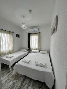 a room with two beds and a chandelier at Denizati Pension in Bodrum City
