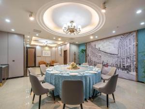 a large dining room with a table and chairs at Magnotel Business Jinan Zoo Wuyingshan North Road Flagship Hotel in Beiyuan