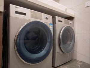 two washing machines sitting next to each other at Magnotel Business Jinan Zoo Wuyingshan North Road Flagship Hotel in Beiyuan