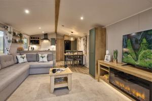 uma sala de estar com um sofá e uma televisão em Seaton Estate em Arbroath