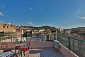 balcón con mesas y sillas y vistas a la ciudad en Riad Fes Lile en Fez