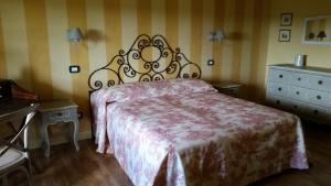 Rocchetta TanaroにあるCascina Rolloneのベッドルーム(大型ベッド1台、ドレッサー付)