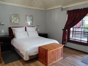 Un dormitorio con una cama grande y una ventana en The Grey's Inn, en Machadodorp