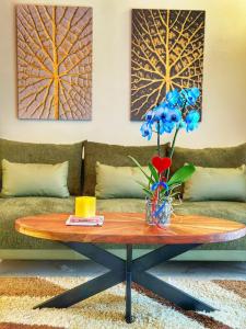 a coffee table with a vase of blue flowers on it at Psimithefto Luxury Apartments in Thessaloniki