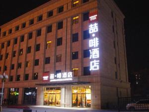 un bâtiment avec un panneau sur son côté dans l'établissement James Joyce Coffetel·Hotan Chuanyi Kaixuan, à Hotan