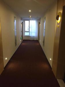 a hallway with a long red carpet in a building at IU Hotels·Tangshan No.1 Middle School North Youyi Road in Beiziyuan