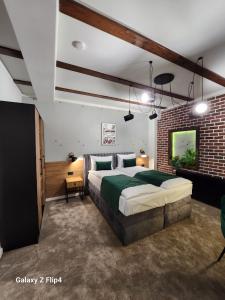 a bedroom with a large bed and a brick wall at IMPERIAL STUDIO in Sibiu