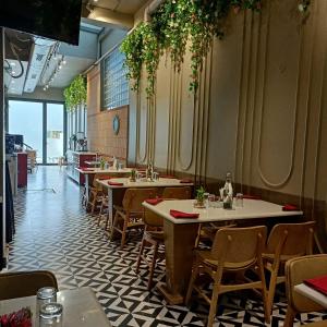 a dining room with tables and chairs in a restaurant at Cosy Grand, Near Chanakyapuri, Embassy Area in New Delhi