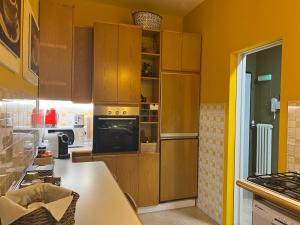 a kitchen with yellow walls and wooden cabinets at Rosanna House in Monza