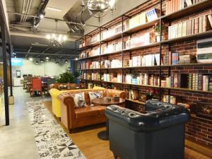 a library with couches and books on shelves at James Joyce Coffetel·Chengdu Chunxi in Chengdu