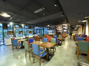 James Joyce Coffetel·Chengdu Chunxi في تشنغدو: مطعم فيه طاولات وكراسي في الغرفة
