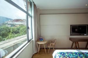 um quarto com uma cama, uma janela e uma mesa em Zmax Lhasa Potala Palace Square em Lassa