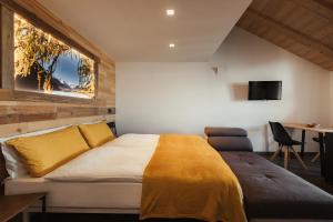 ein Schlafzimmer mit einem großen Bett und einer gelben Decke in der Unterkunft Bonvivar -- Mountain Guesthouse in Livigno