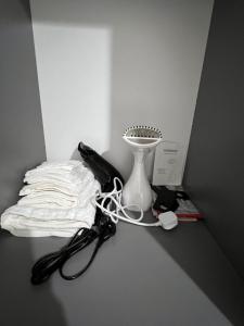 a table with a phone and a white vase at F4 Luxury Stays One bed apartment with Parking in Ilford