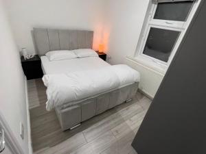 a small bedroom with a bed and a window at F4 Luxury Stays One bed apartment with Parking in Ilford