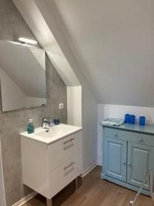 bagno con lavandino e specchio di Le Moulin de la Butte a Huisnes-sur-Mer