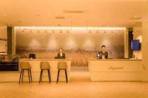 dos hombres sentados en un mostrador en un restaurante en Magnotel Jining Jiaxiang Zengzi Avenue, en Jiaxiang
