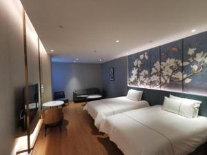 ein Hotelzimmer mit 2 Betten und einem TV in der Unterkunft Magnotel Jining Jiaxiang Zengzi Avenue in Jiaxiang