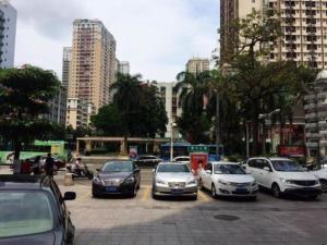 un grupo de autos estacionados en un estacionamiento en Jinjiang Inn Style Huizhou Xihu Park Walking Street en Huizhou