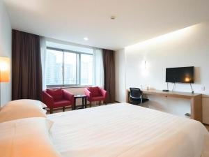 um quarto de hotel com uma cama, uma mesa e cadeiras em Jinjiang Inn Style Huizhou Xihu Park Walking Street em Huizhou