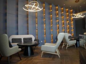 una sala de espera con sillas, mesas y una pared en Jinjiang Inn Select Jiuquan Wanda Plaza en Jiuquan