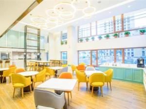 哈爾濱的住宿－Magnotel Harbin Songbei Wanda Wenlvcheng，餐厅设有桌椅和窗户。