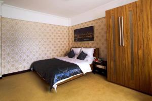 um quarto com uma cama e um armário de madeira em Chonpines Hotels·XiNing Qingzang Building em Xining