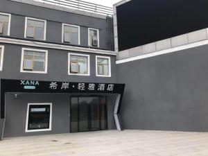een grijs gebouw met een bord erop bij Xana Lite Beijing Huangcun West Street Metro Station in Daxing