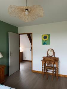 Le Moulin de la Butte في Huisnes-sur-Mer: غرفة نوم مع طاولة ومروحة سقف
