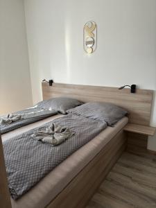 a bed with two pairs of shoes on it at Oasis Apartman in Hajdúszoboszló