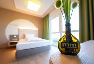 un jarrón con flores sentado en una mesa en una habitación en Mainfranken Motel - Anreise rund um die Uhr - Neueröffnung 2023, 