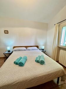 una camera da letto con un letto e due asciugamani di Jennas-Green Apartment a Cardedu