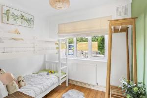sypialnia dla dzieci z łóżkiem piętrowym i oknem w obiekcie Bramblewood - Cosy chic, hot tub, close to beach w mieście Stokeinteignhead