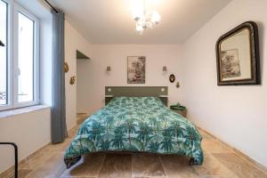 a bedroom with a bed with a green comforter at La maison de Lili aux portes du Luberon in Cavaillon