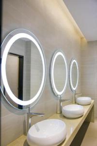 łazienka z 2 umywalkami i 2 lustrami w obiekcie Lavande Hotels·Qionghai Boao w mieście Xinshi
