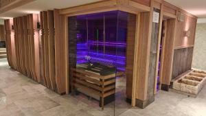 Zimmer mit einer Dusche mit violetten Lichtern in der Unterkunft Aries Hotel & SPA Szczyrk in Szczyrk