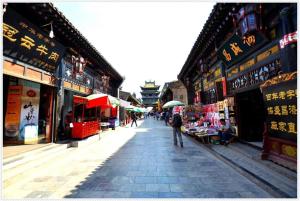 Una persona che cammina per una strada in una città asiatica di Lavande Hotels·Jinzhong Pingyao Old Town a Pingyao