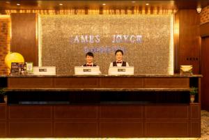 two men sitting at a desk with laptops at James Joyce Coffetel Linfen Xiangyang West Road in Linfen